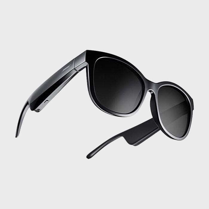 Black sunglasses hover on a white background, displaying a sleek, modern design with tinted lenses and thick, curved frames.