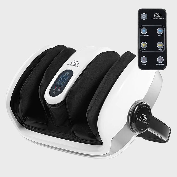 Foot massager with remote, displaying controls for pressure, sway, roll, vibe, heat, program. White device with black padding against a plain background.