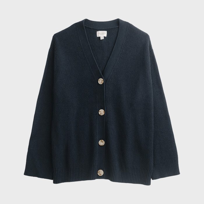 Black cardigan hanging, featuring five brown buttons, against a plain white background.