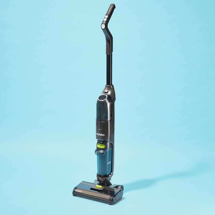 A black upright vacuum cleaner stands on a light blue background.