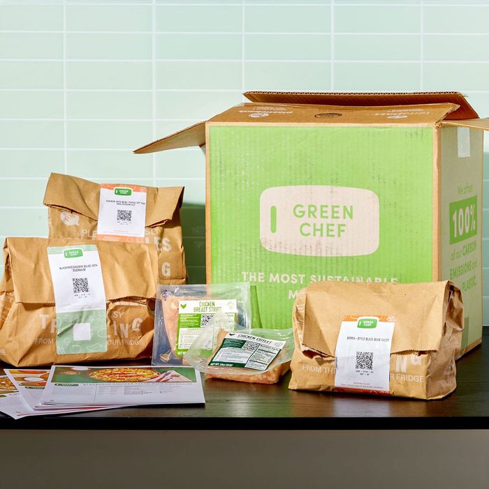 Box sits open; paper bags and packaged food items lie in front. 