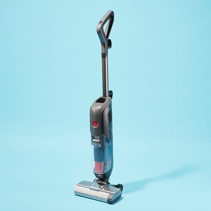 Vacuum cleaner standing upright on a light blue background.