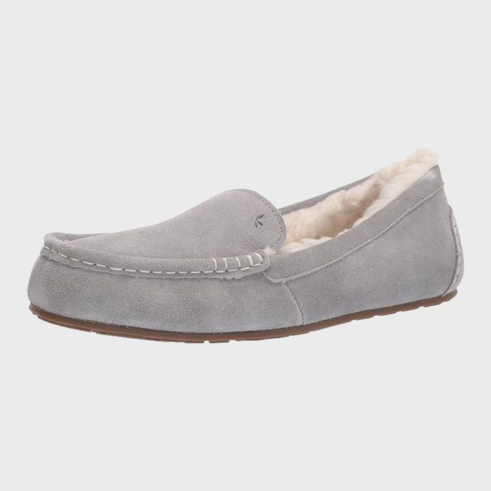 Gray suede shoe rests on a plain white background; features stitching and plush-lined interior with a thin brown sole.