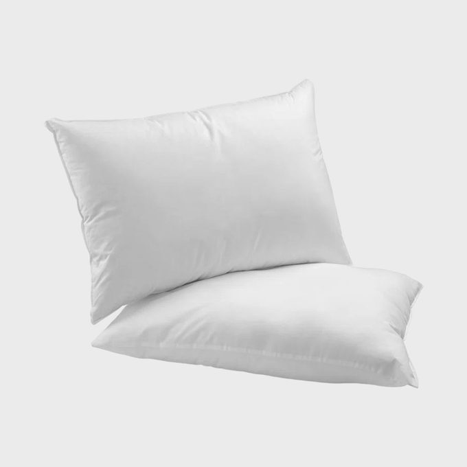 Two white pillows rest overlapping, set against a simple, light gray background.