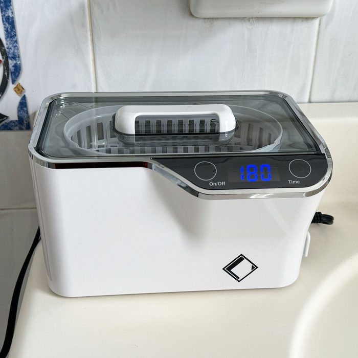 White ultrasonic cleaner with digital display shows 