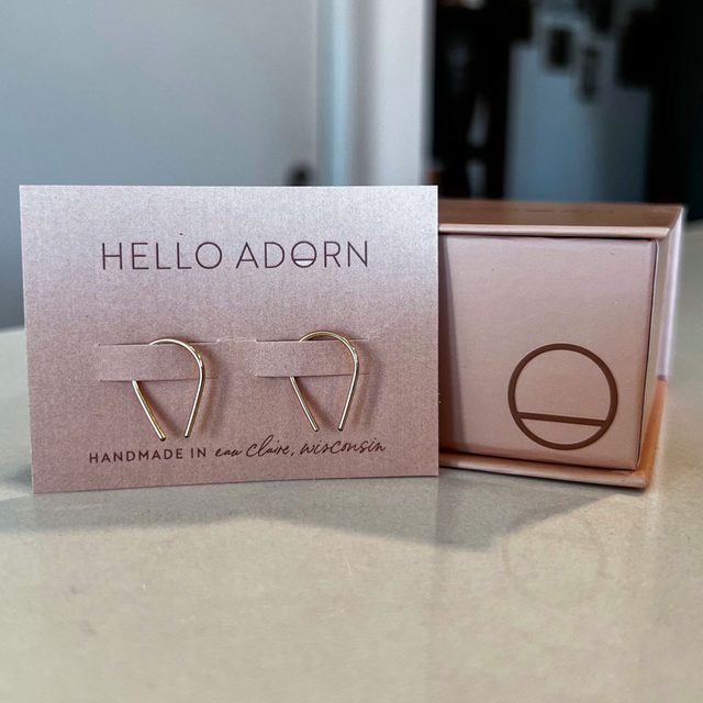 Earrings rest on a display card labeled 