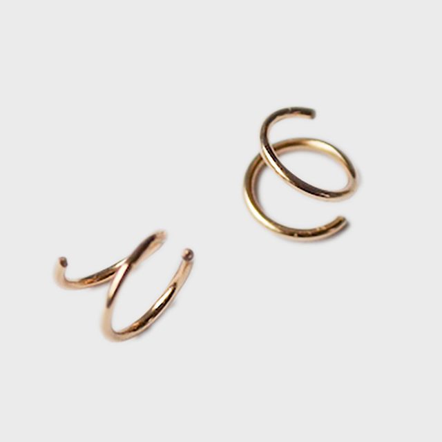 Two gold spiral rings resting on a plain white background.