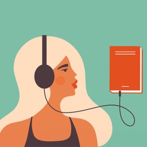 A person with headphones listens to an orange book connected by a cable, against a simple green background.