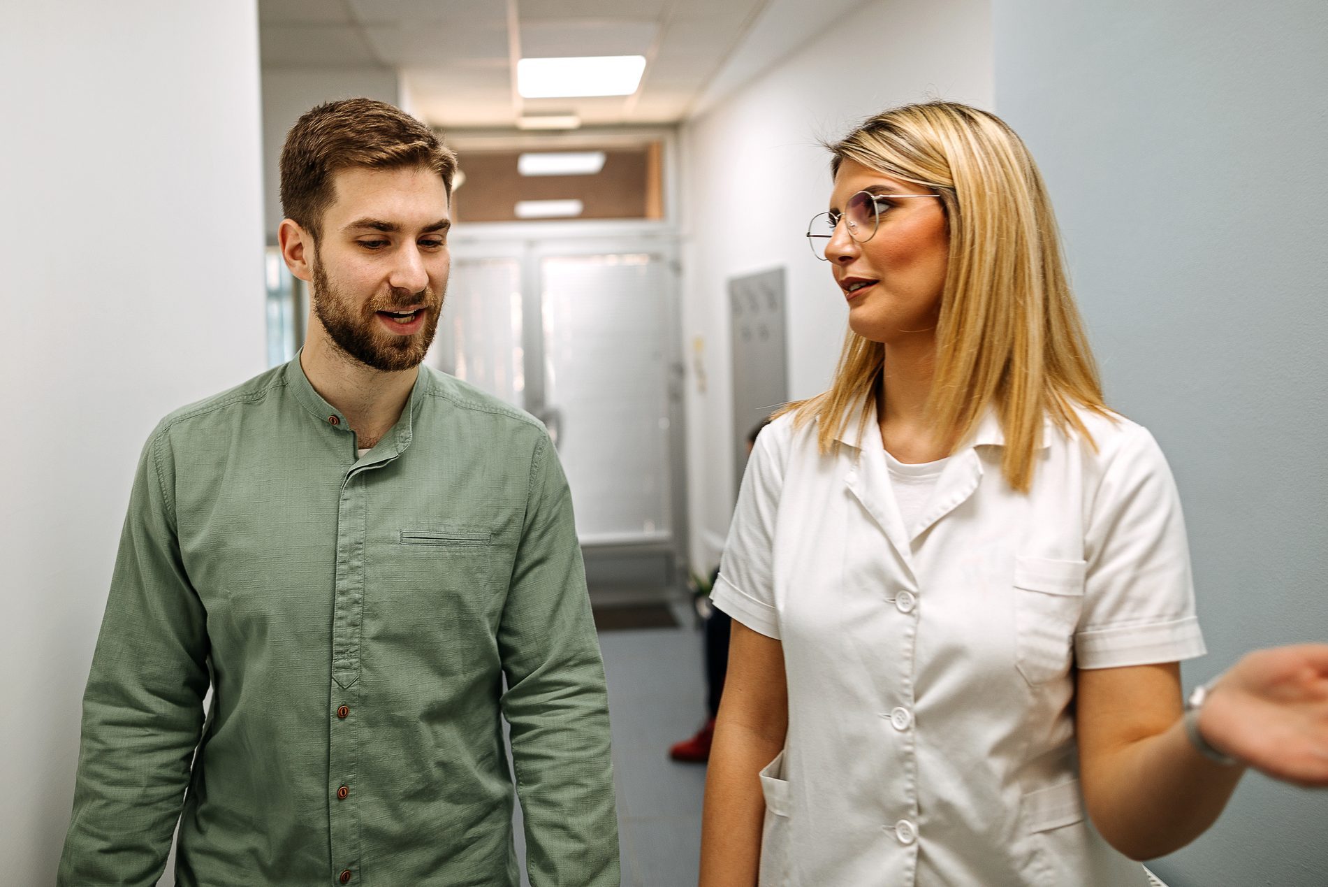 Patient and female nurse walking through the hospital and talking