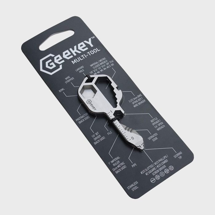 Key-shaped multi-tool featuring various functions; displayed on a labeled packaging card describing uses like bottle opener and screwdriver; minimalist white background.
