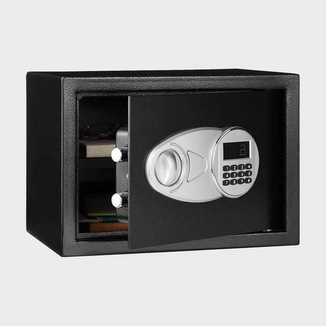 Black safe sits open, revealing interior contents, featuring a digital keypad with numbers and a display, against a plain background.