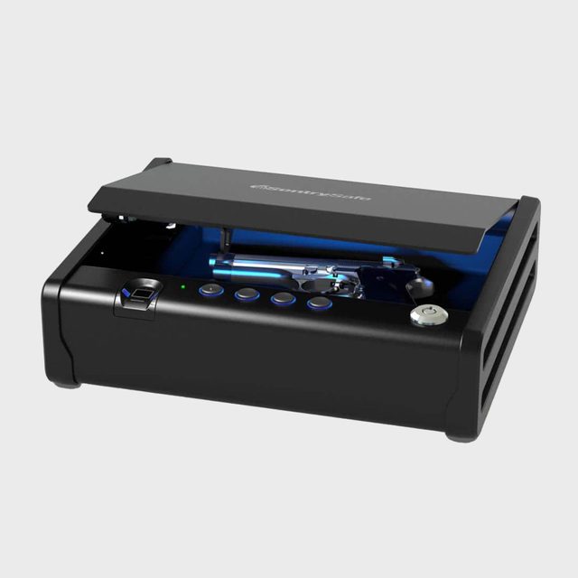 Safe holds a handgun; lid slightly open, revealing buttons and biometric scanner. Located in a well-lit, minimal space. Text: 