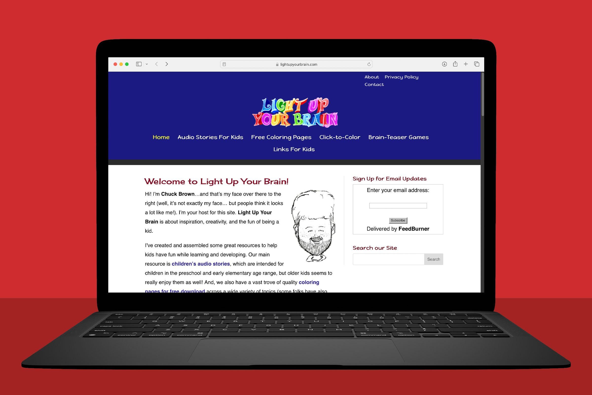 A laptop displays a colorful website about children's educational resources on a plain red background.