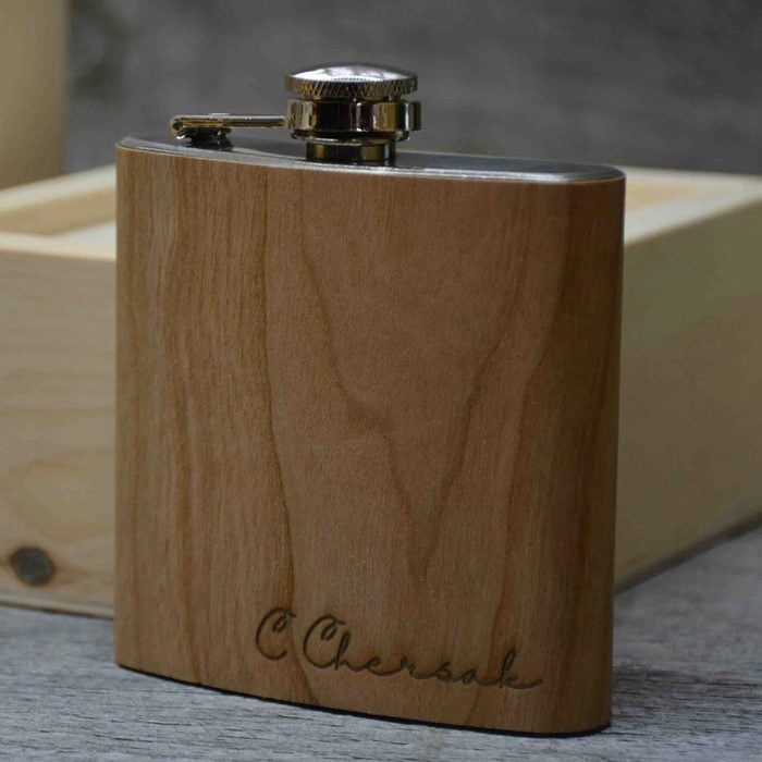 A wooden flask stands on a wooden surface with 