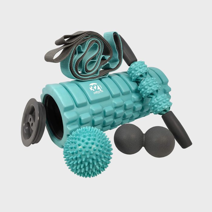 Foam roller rests with massage balls, straps, and a spiky ball, providing a set for physical therapy or exercise on a plain background.