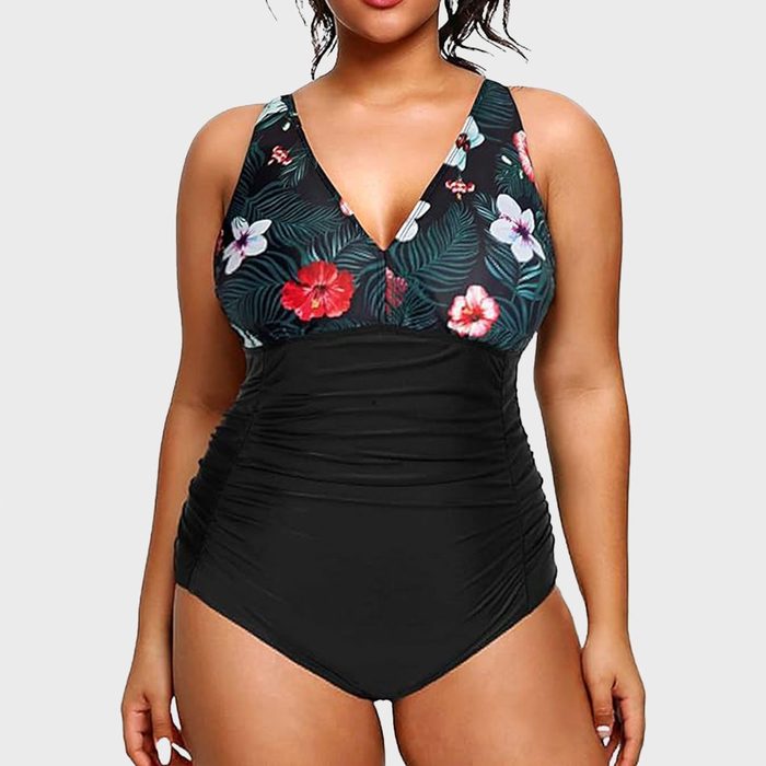 Swimsuit features floral pattern on top and solid black bottom, modeled against a plain light gray background.