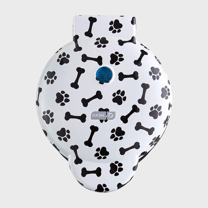 Waffle maker featuring dog bone and paw print designs, seen from above; white background emphasizes decorative pattern. 