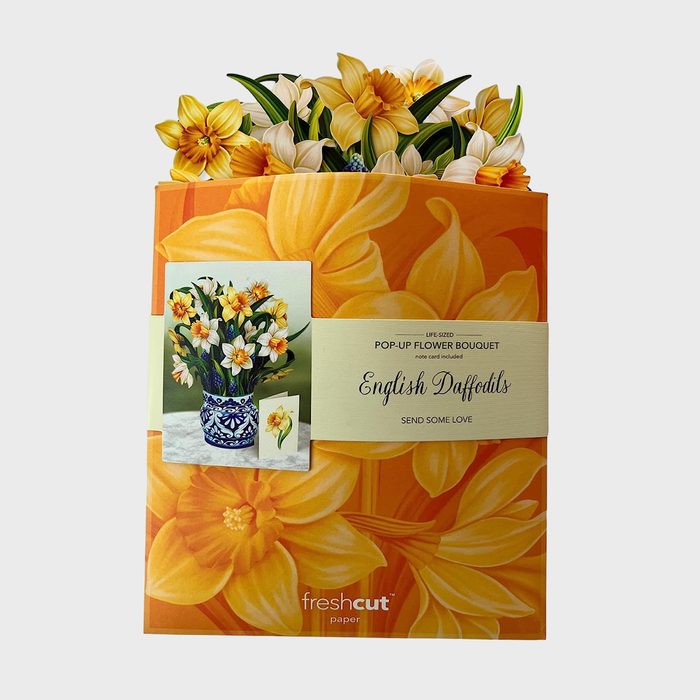 The pop-up daffodil bouquet emerges from vibrant packaging depicting flowers, accompanied by text: 