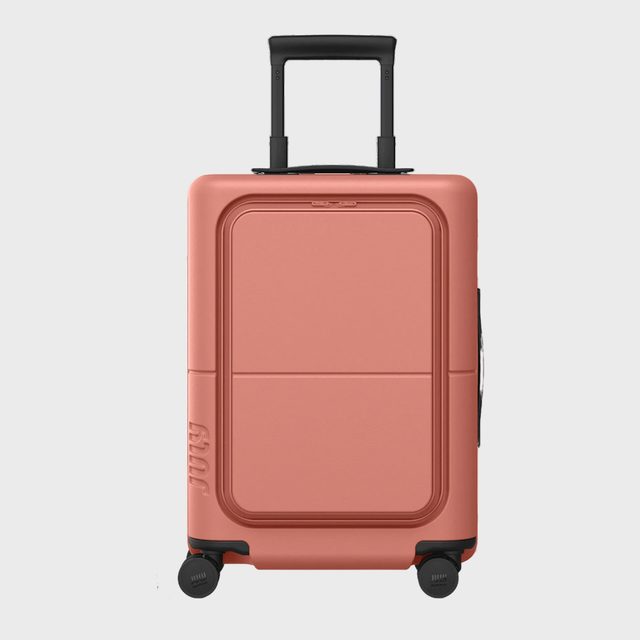 Suitcase stands upright, handles extended, surrounded by a neutral background.