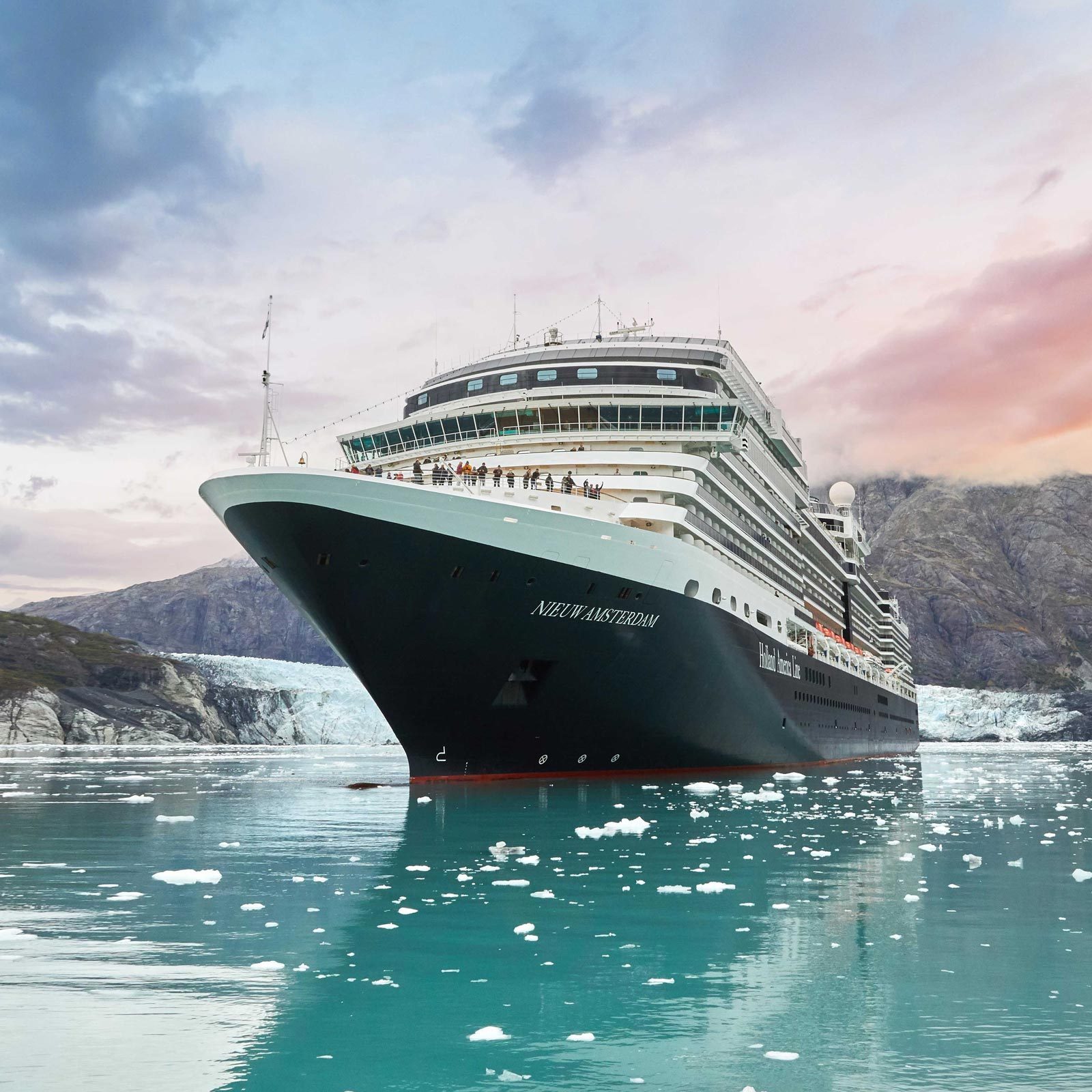 A large cruise ship sails through icy waters, surrounded by mountains and glaciers. Text on the ship's bow reads "NIEUW AMSTERDAM."