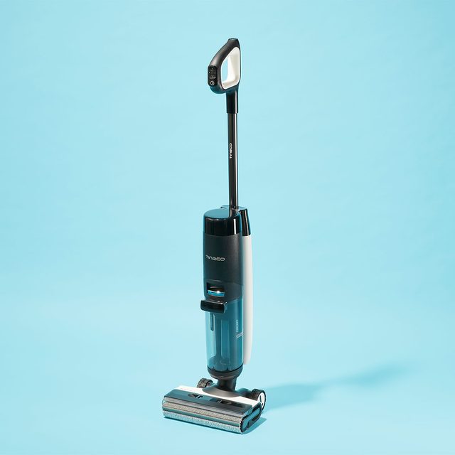 Vacuum cleaner stands upright on a light blue background, with visible brand name 