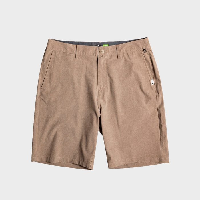 Khaki shorts lying flat, facing up with button and zipper closed, surrounded by a plain, light gray background.