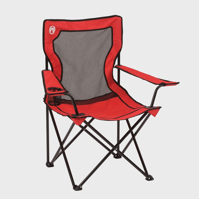 Red folding chair stands open with mesh backrest, cup holder on armrest, and black metal framework. Set in a plain, neutral background.