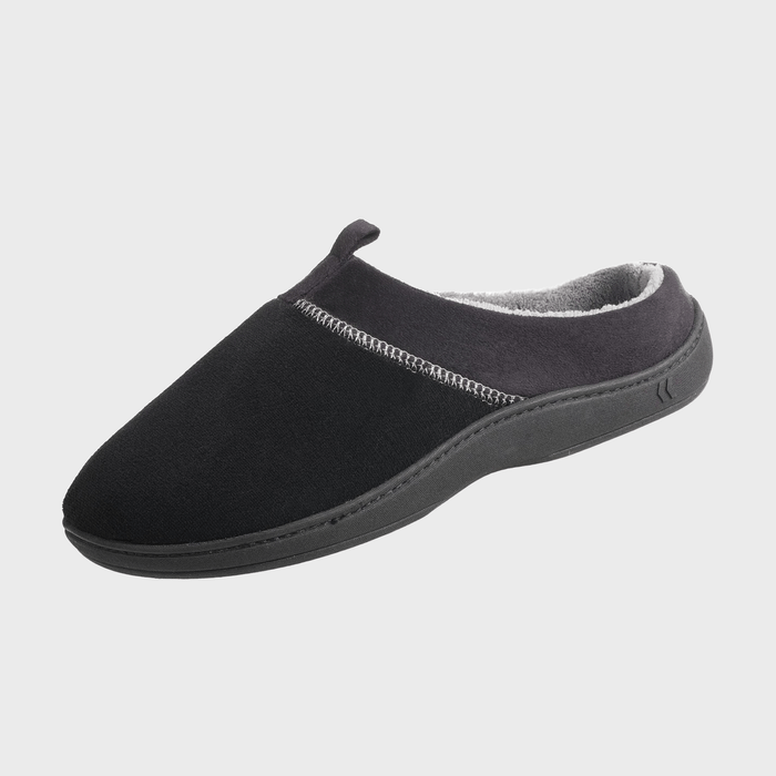 A black slipper, with grey fleece lining, rests on a plain white background. The design includes a textured sole for indoor comfort.