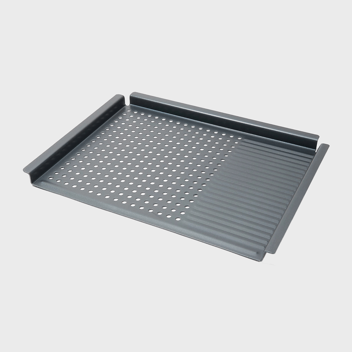 Baking tray with perforated metal surface and ridged section, placed on a plain light gray background.