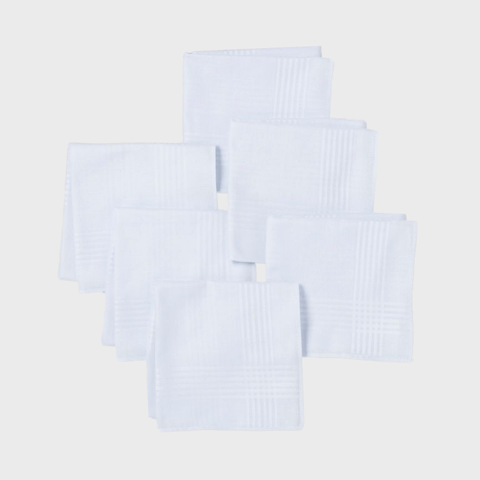 White handkerchiefs lie neatly arranged overlapping each other against a plain gray background.