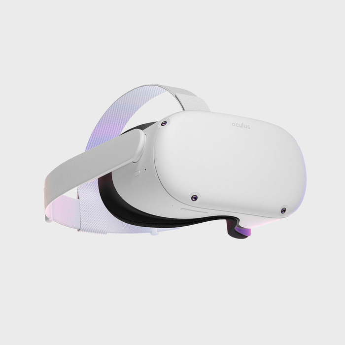 A white virtual reality headset with adjustable straps and front-facing cameras on a plain gray background. The brand 