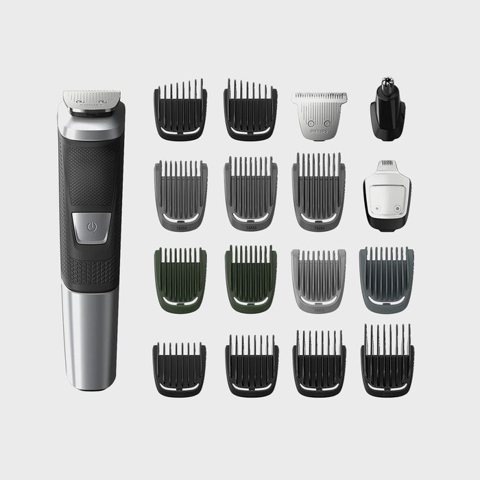 Grooming kit includes a trimmer with on/off switch, various attachment guards, and heads, arranged neatly on a plain background.