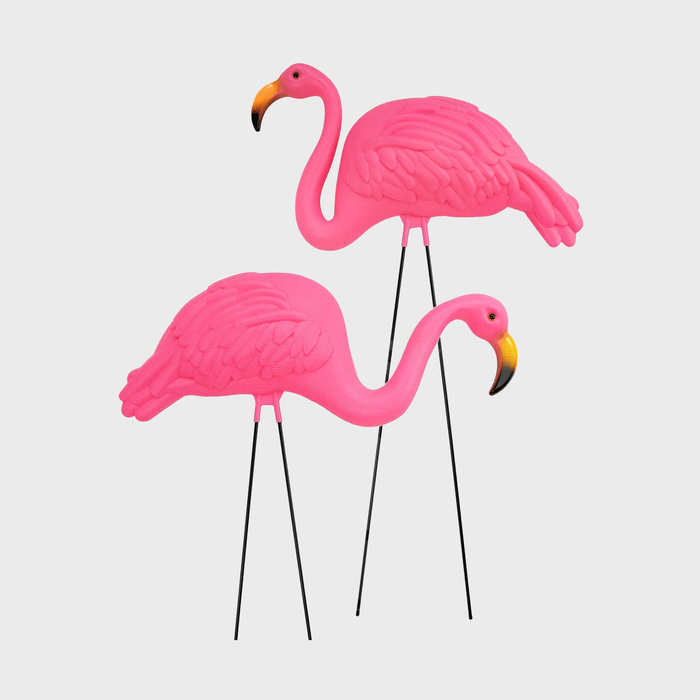 Pink flamingo lawn ornaments stand on black metal legs against a plain white background.