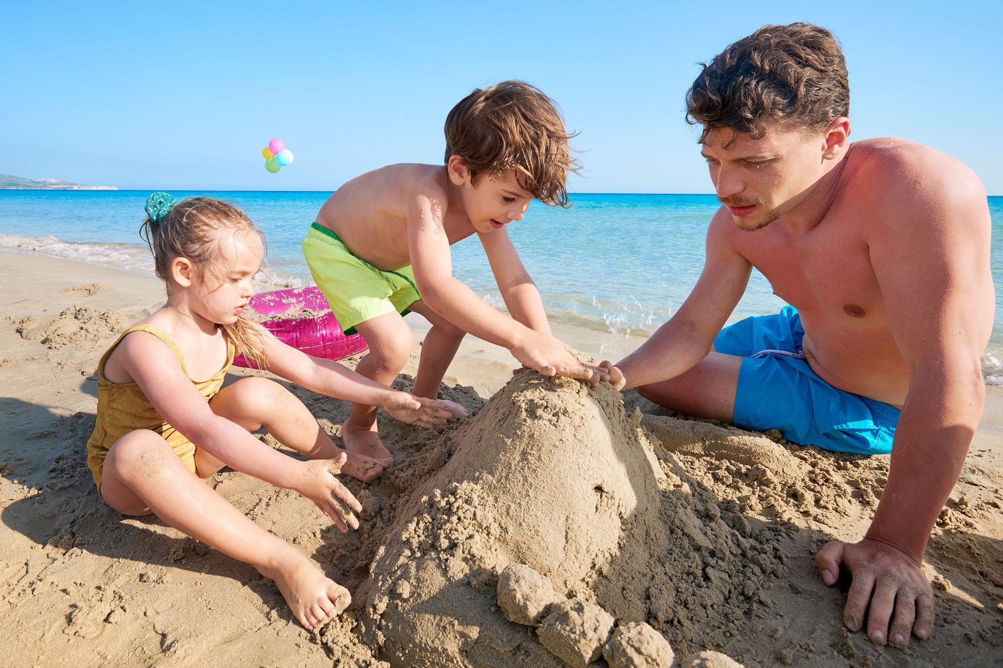 Family On The Beach Playing With Sand