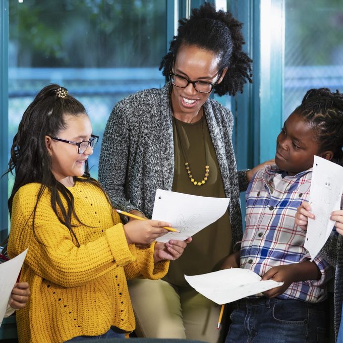 Elementary students showing their thank you note to teacher