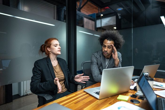 Worried coworkers talking on a board room at office