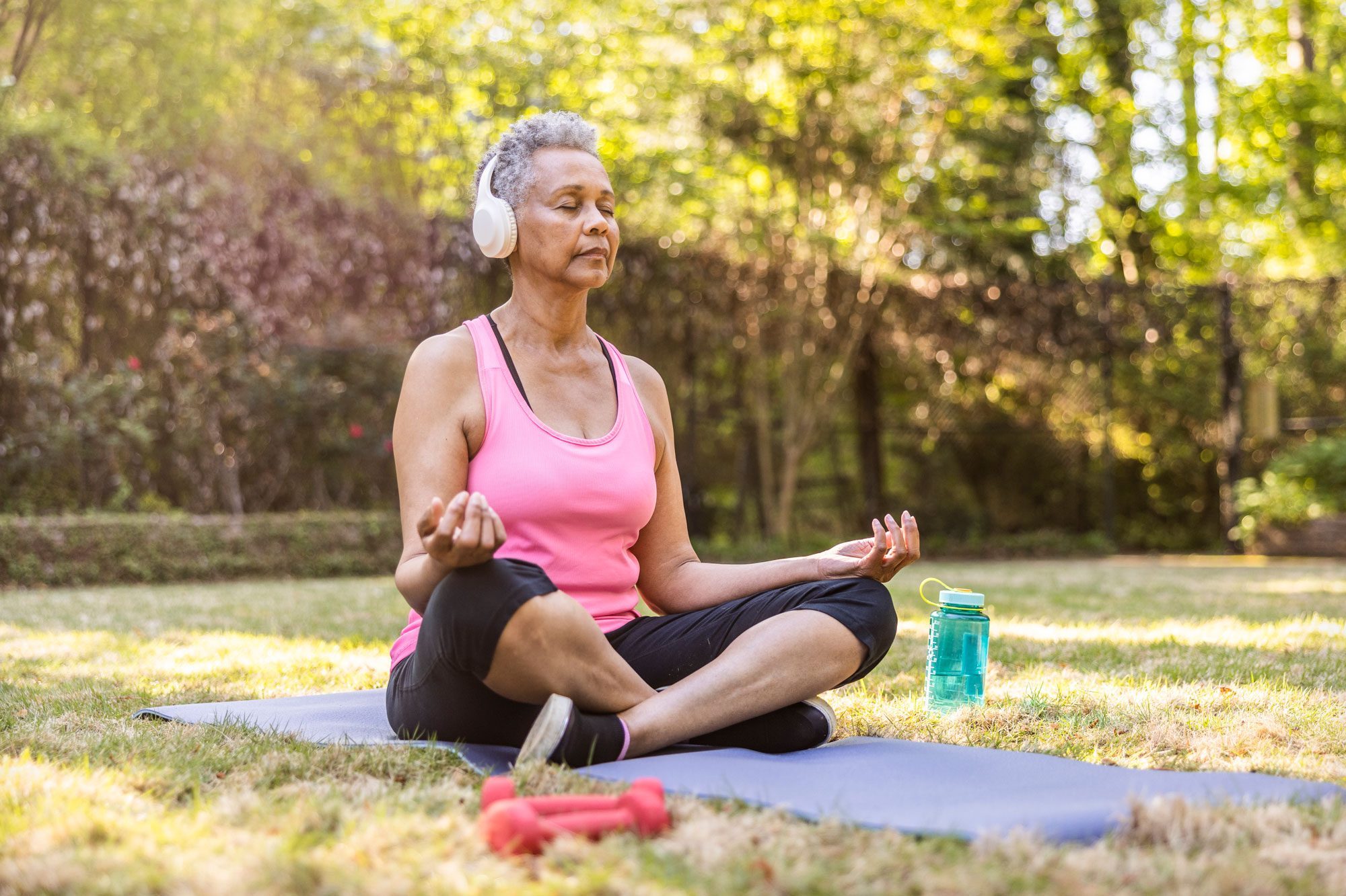 Senior Woman Meditating In Beautiful Garden