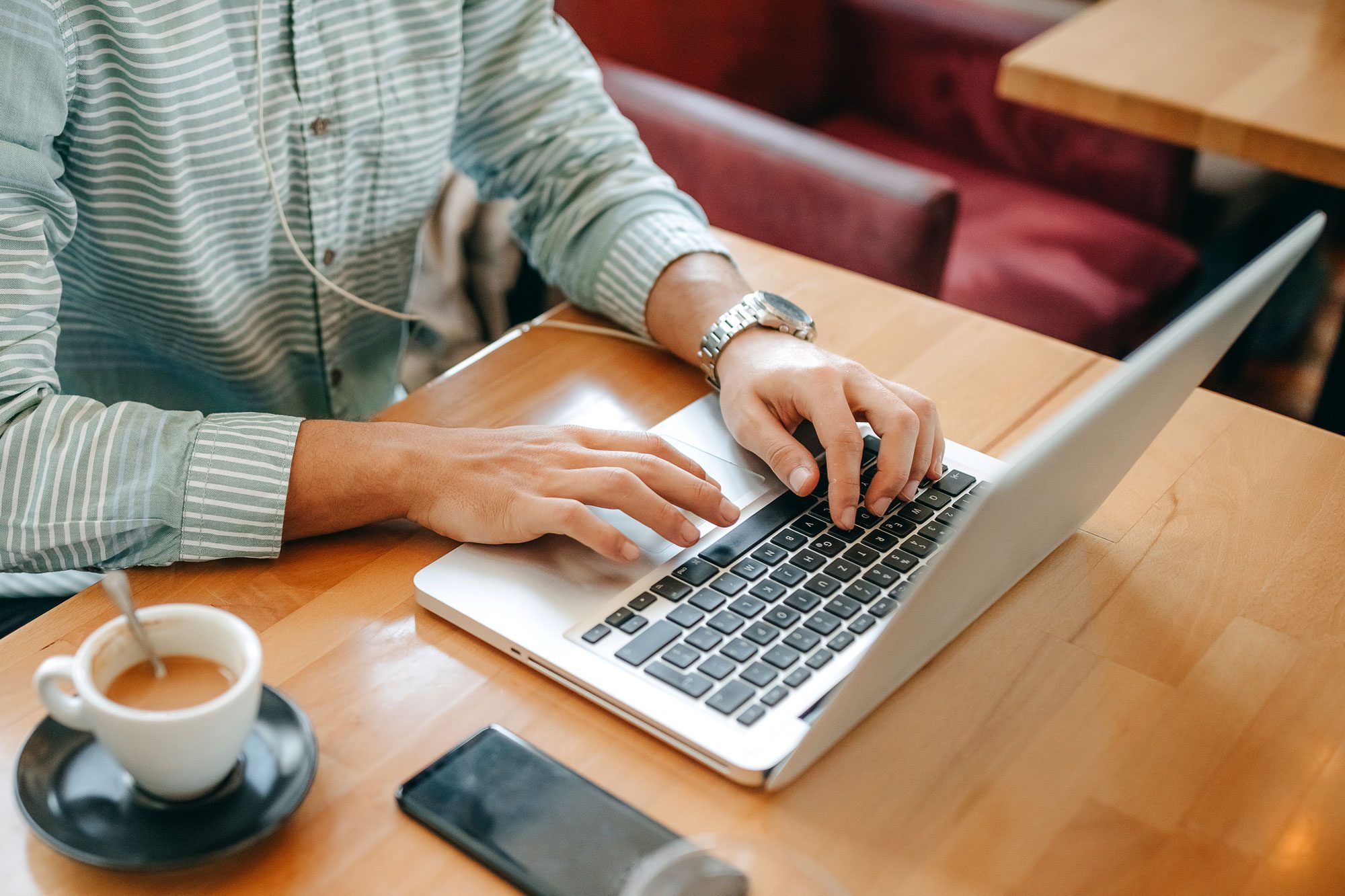 Shot Of A Handsome Young Man Using A Laptop In A Coffee Shop