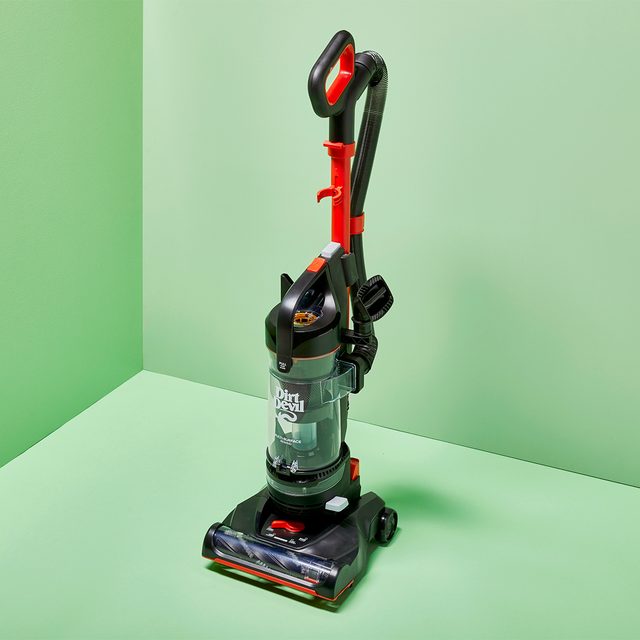 Vacuum cleaner stands upright on a mint-green, box-like floor and wall background, with visible 