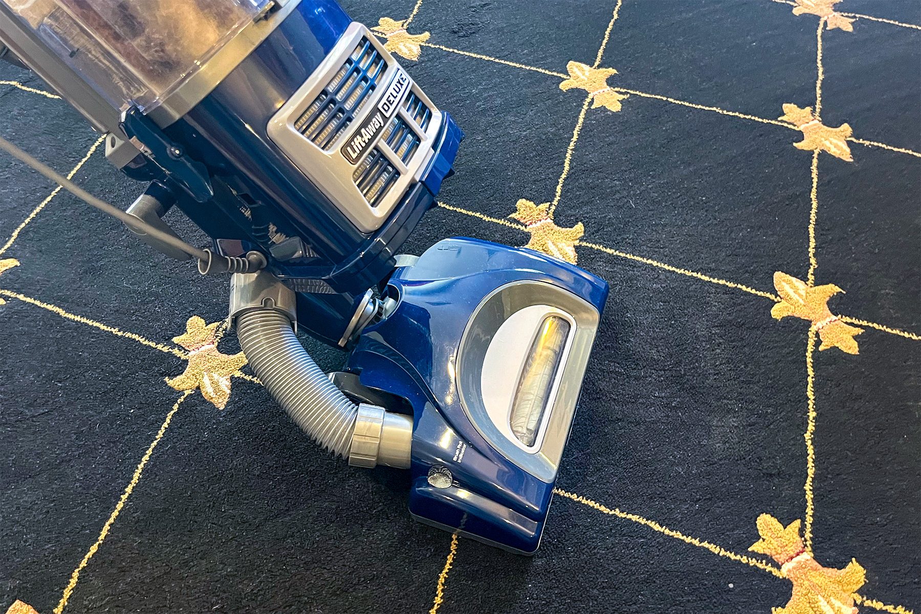 Shark navigator vacuum being used on a carpet.