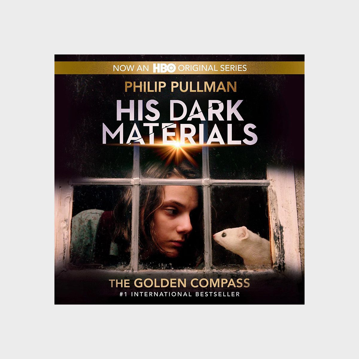 Person looks at a small white animal through a window. Text: "Philip Pullman His Dark Materials The Golden Compass #1 International Bestseller."