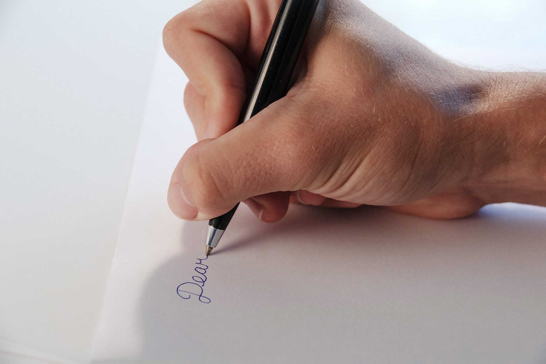 'Dear' handwritten on paper.