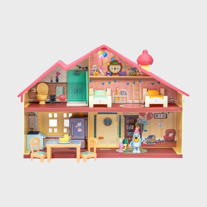 Dollhouse displays colorful furniture and character figures inside; includes bedrooms, bathroom, and kitchen, set against a playful cartoon-style backdrop.