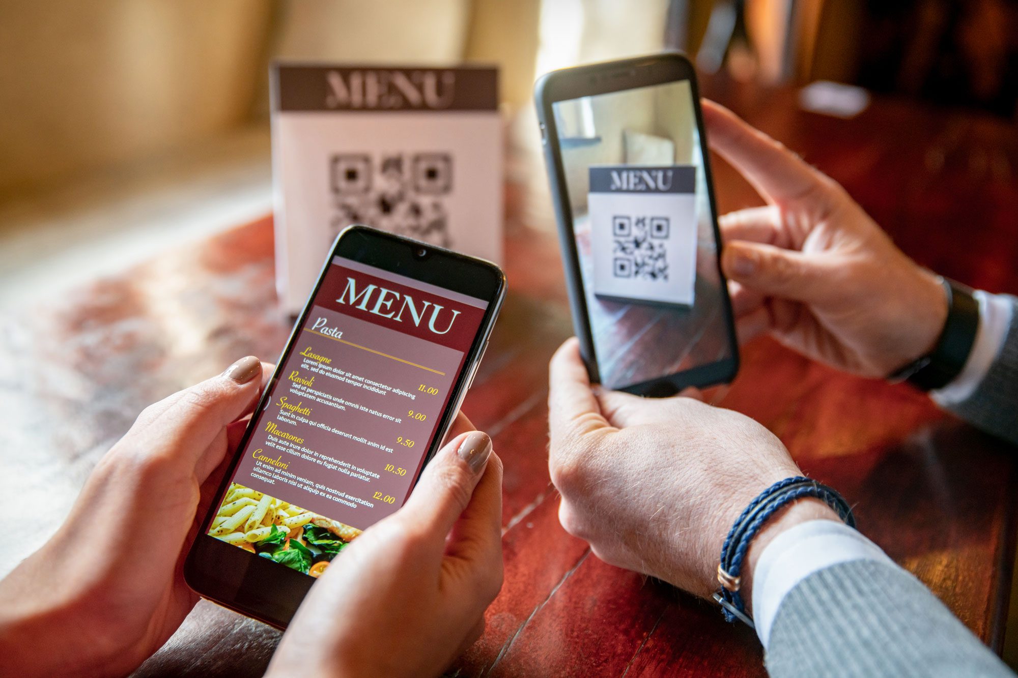 Couple At A Restaurant Scanning The Menu With Qr Codes Using Their Cell Phones