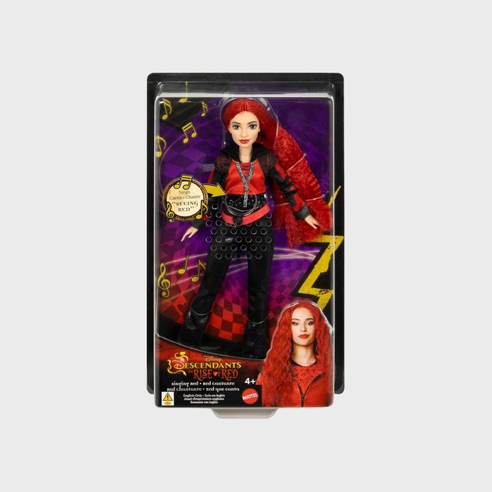 Doll with red hair and stylish outfit stands in colorful packaging. Text reads: 