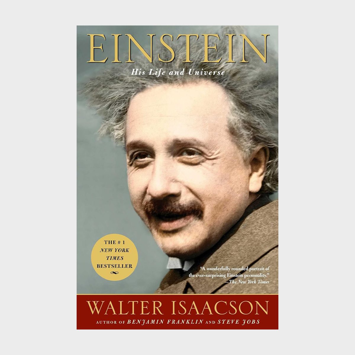 A smiling man with messy hair, wearing a brown coat, is on a book cover titled "Einstein: His Life and Universe" by Walter Isaacson.