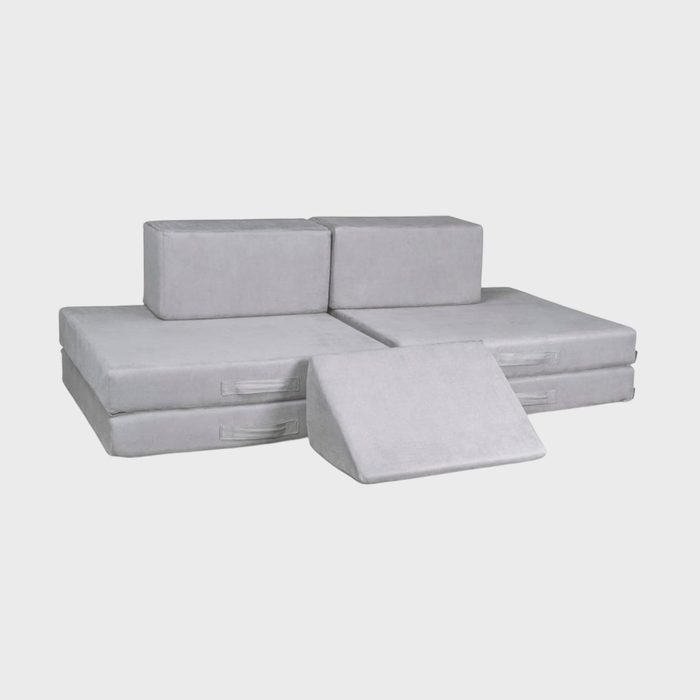 Gray modular sofa with detachable cushions displayed against a plain background. Cushions are stacked and arranged in different positions, showcasing flexibility.