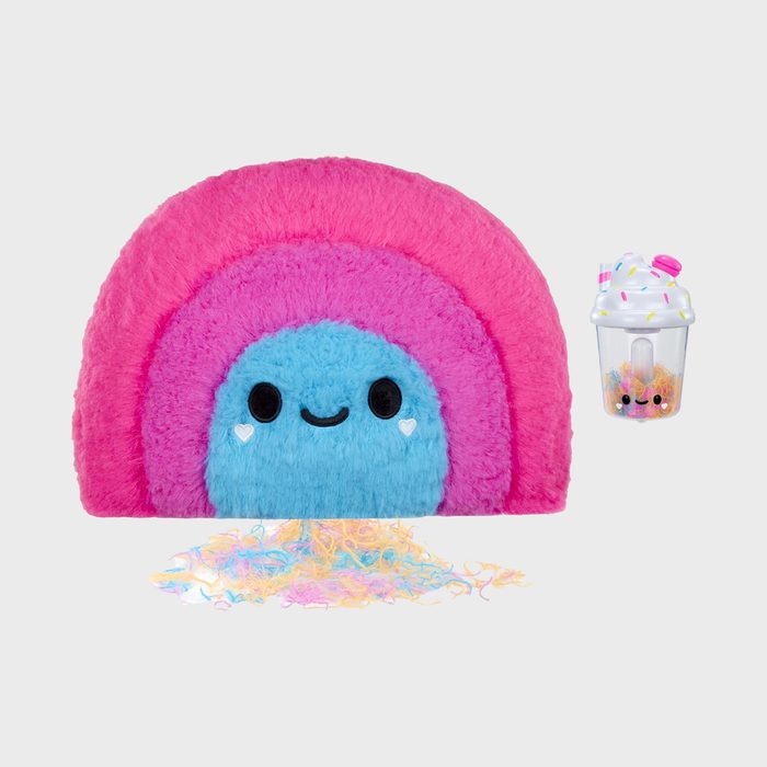 Rainbow plush toy smiling, surrounded by colorful shredded strands. Nearby, a small cup with sprinkles and a smiling face.