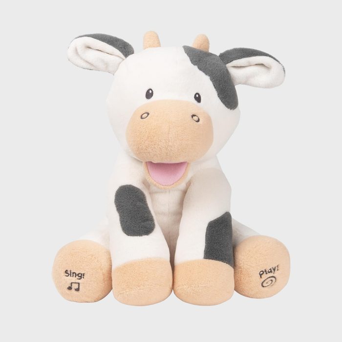 Stuffed cow toy smiling, sitting upright with 