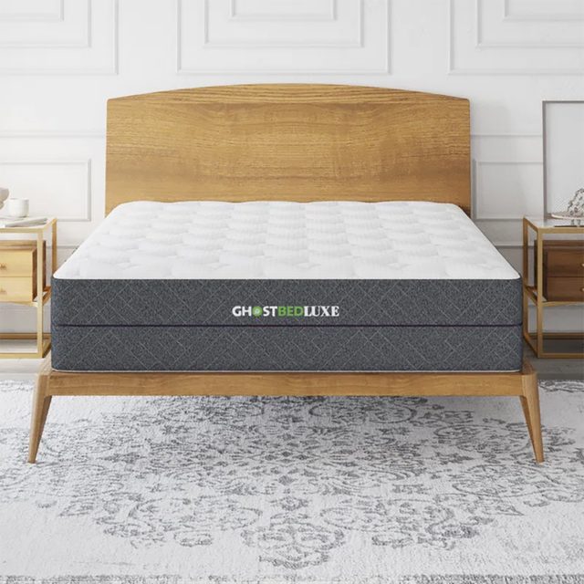 Mattress resting on a wooden bed frame, labeled 